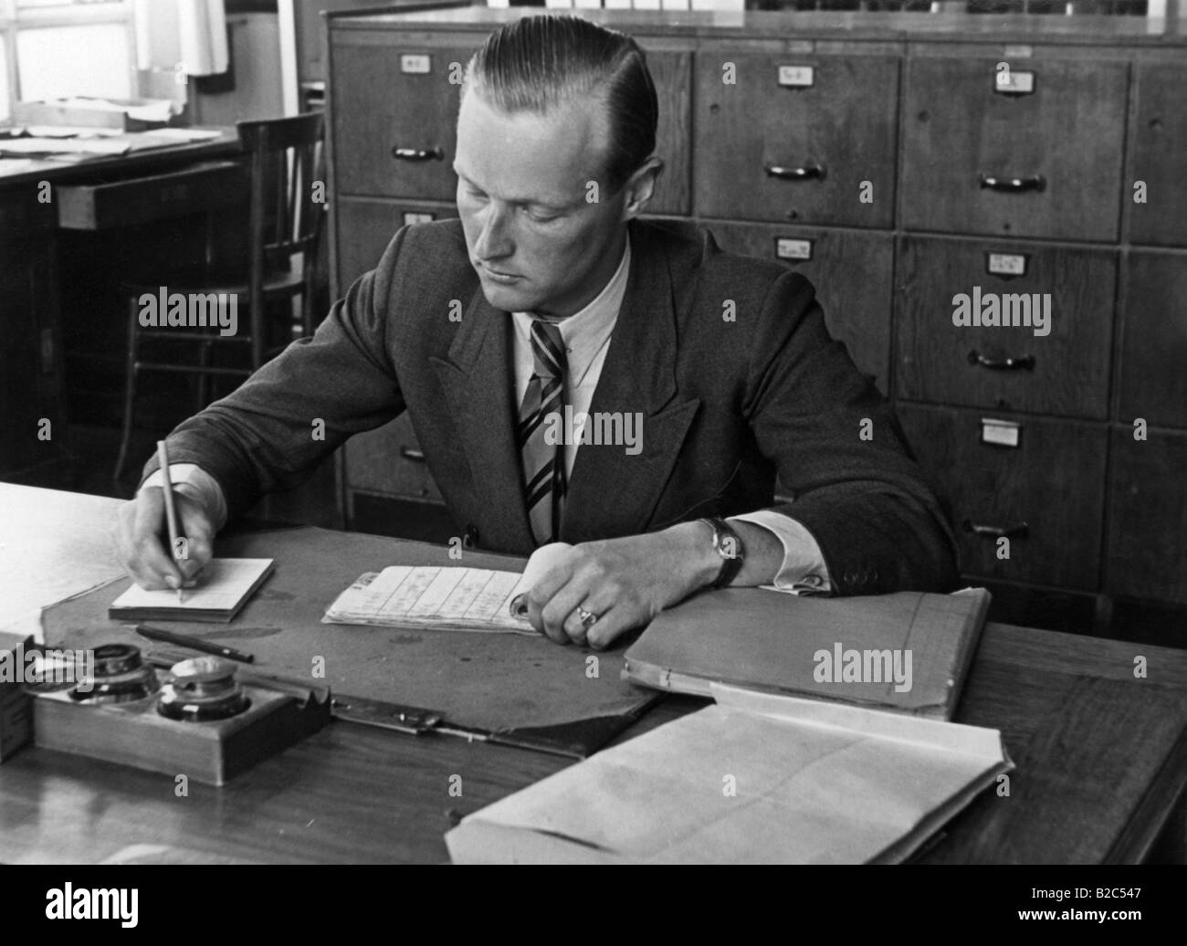 Mann in seinem Büro, historische Bild von etwa 1940 schreiben Stockfoto