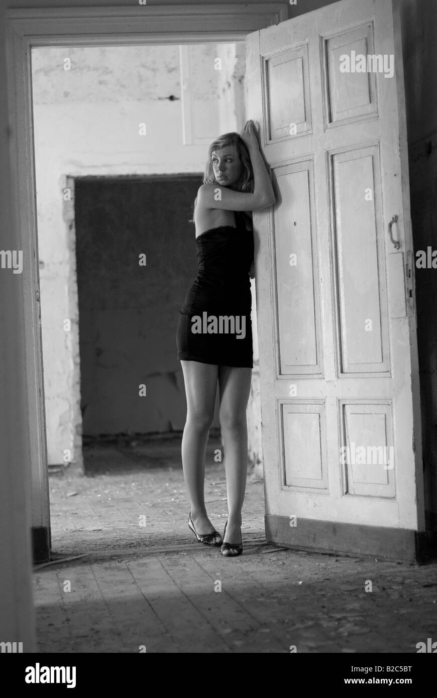 junge Frau mit eleganten Kleidern posiert in niederzuschlagen, Gebäude Stockfoto