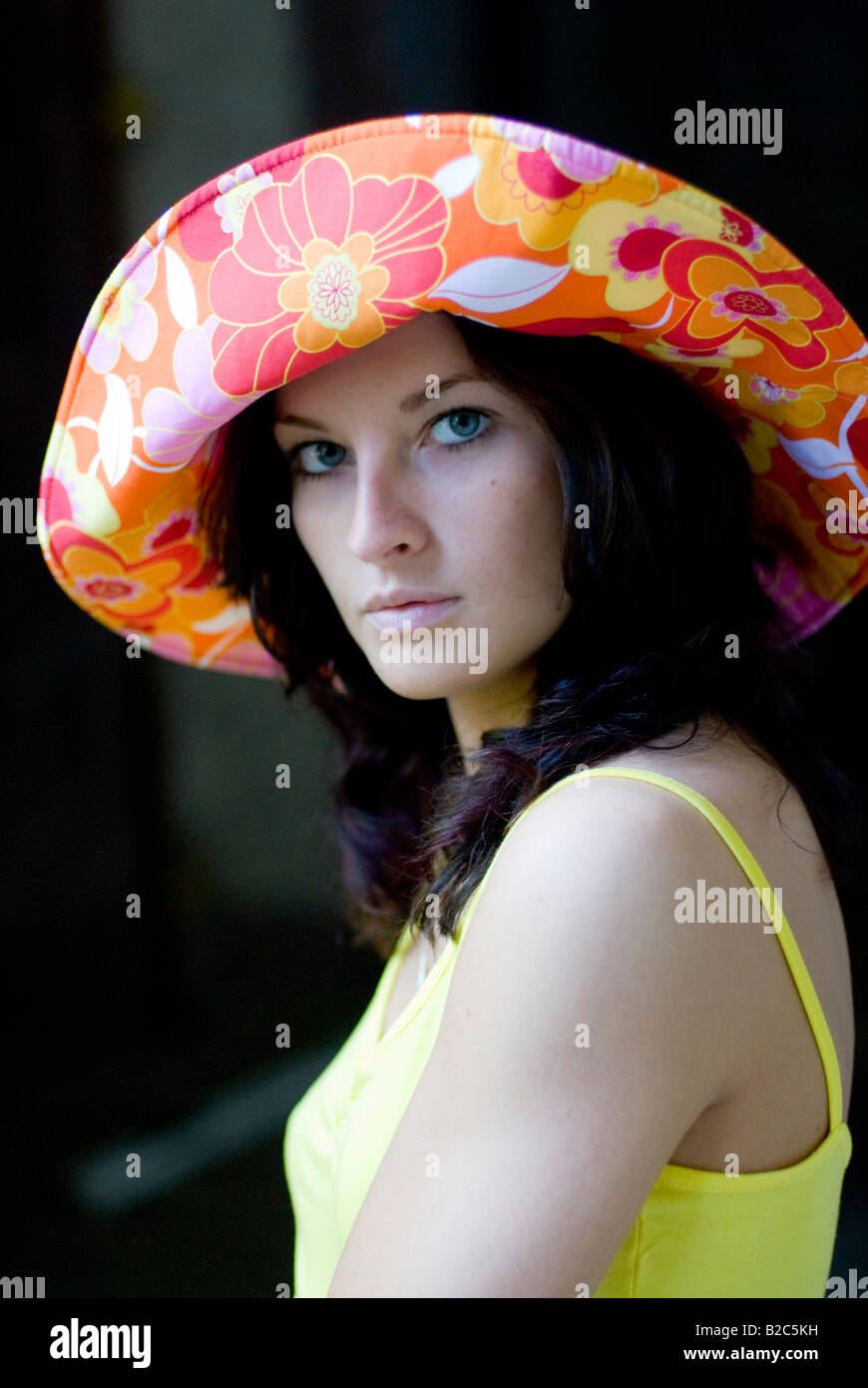 niedliche dunkelhaarige Frau mit einem bunten Hut Stockfoto