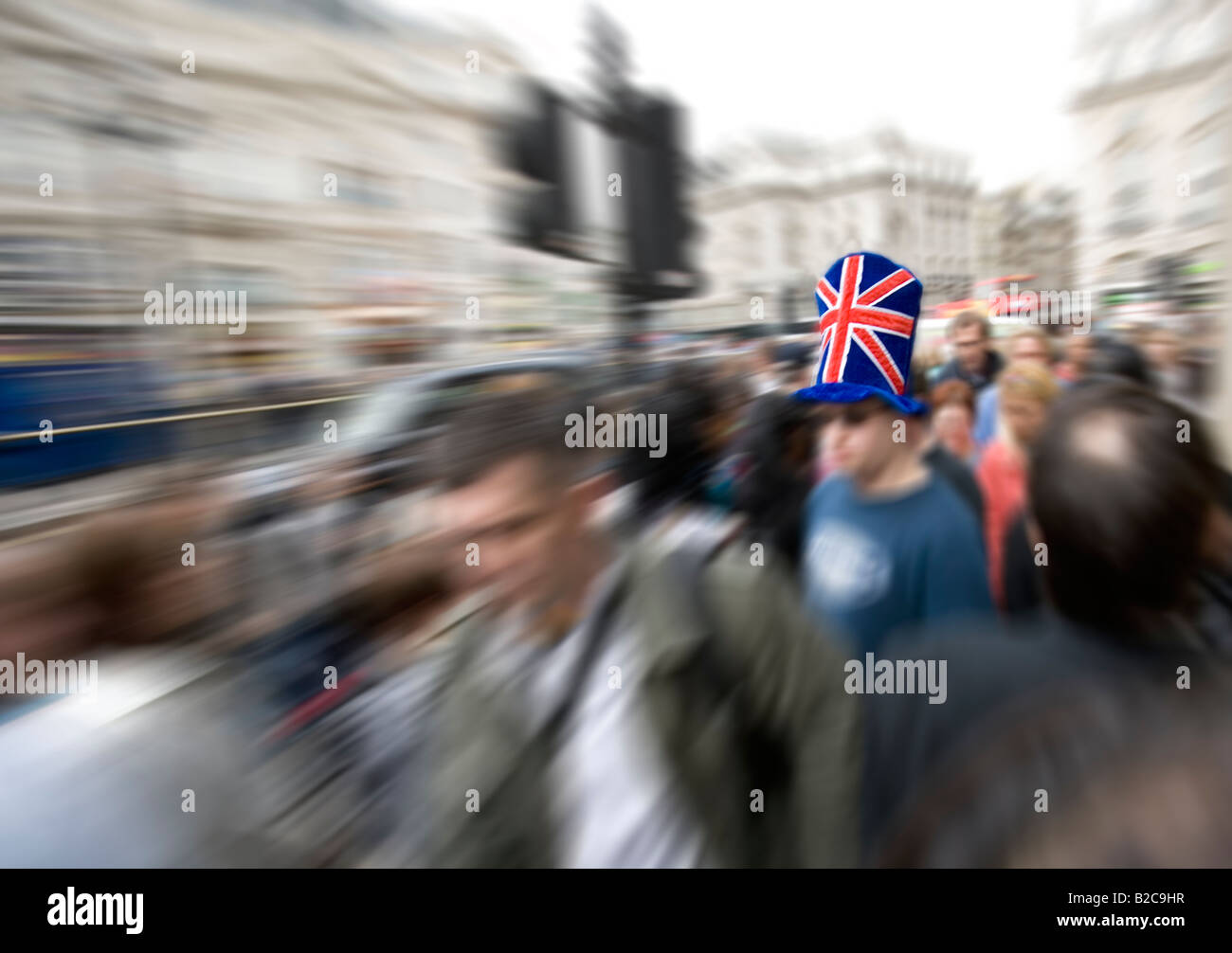 Mann mit Hut der Anschluß-Markierungsfahne in überfüllten Piccadilly Circus London Stockfoto