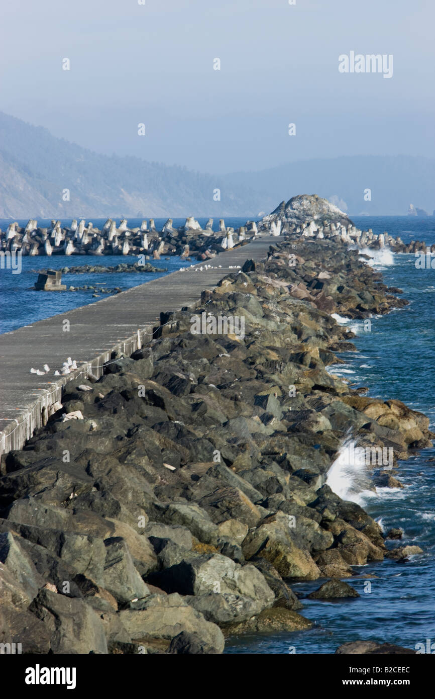 Steg mit Felsbrocken, konkrete Hafen Betonblöcken & Tetrapoden zu schützen. Stockfoto