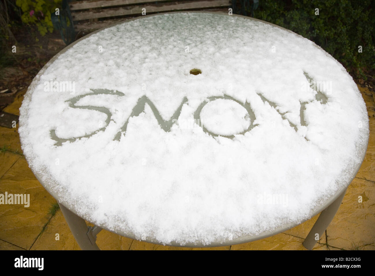 Das Wort Schnee geschrieben im Schnee auf einem Glas gekrönt Gartenterrasse Tabelle. Dorset. VEREINIGTES KÖNIGREICH. Stockfoto