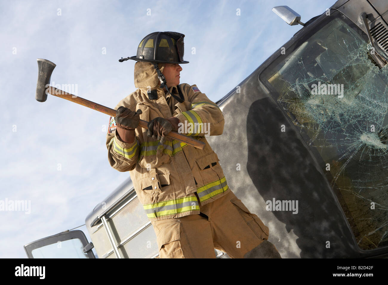 Feuerwehrmann schlagen abgestürztes Auto mit Axt Stockfoto