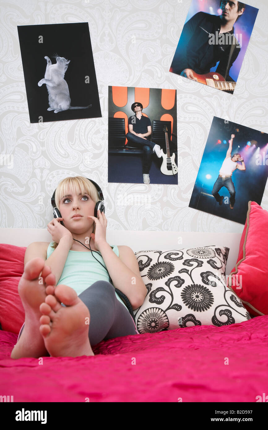 Teenager-Mädchen (16-17) sitzen am Bett, Musik hören Stockfoto