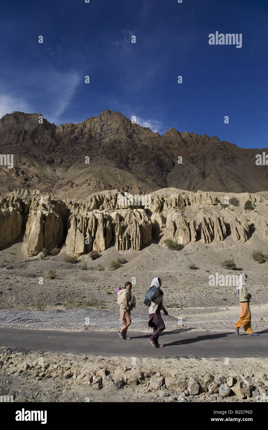 Bäuerinnen auf dem Heimweg aus den Bereichen. Schnee, erodierten Hoodoos im Hintergrund gesehen werden können. Spiti, Himachal Pradesh. Stockfoto