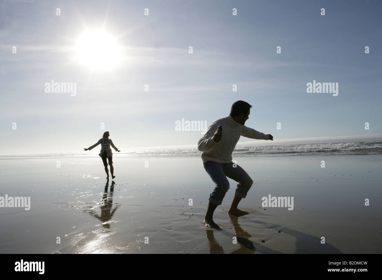 Junges Paar überspringen Felsen am Strand. Stockfoto