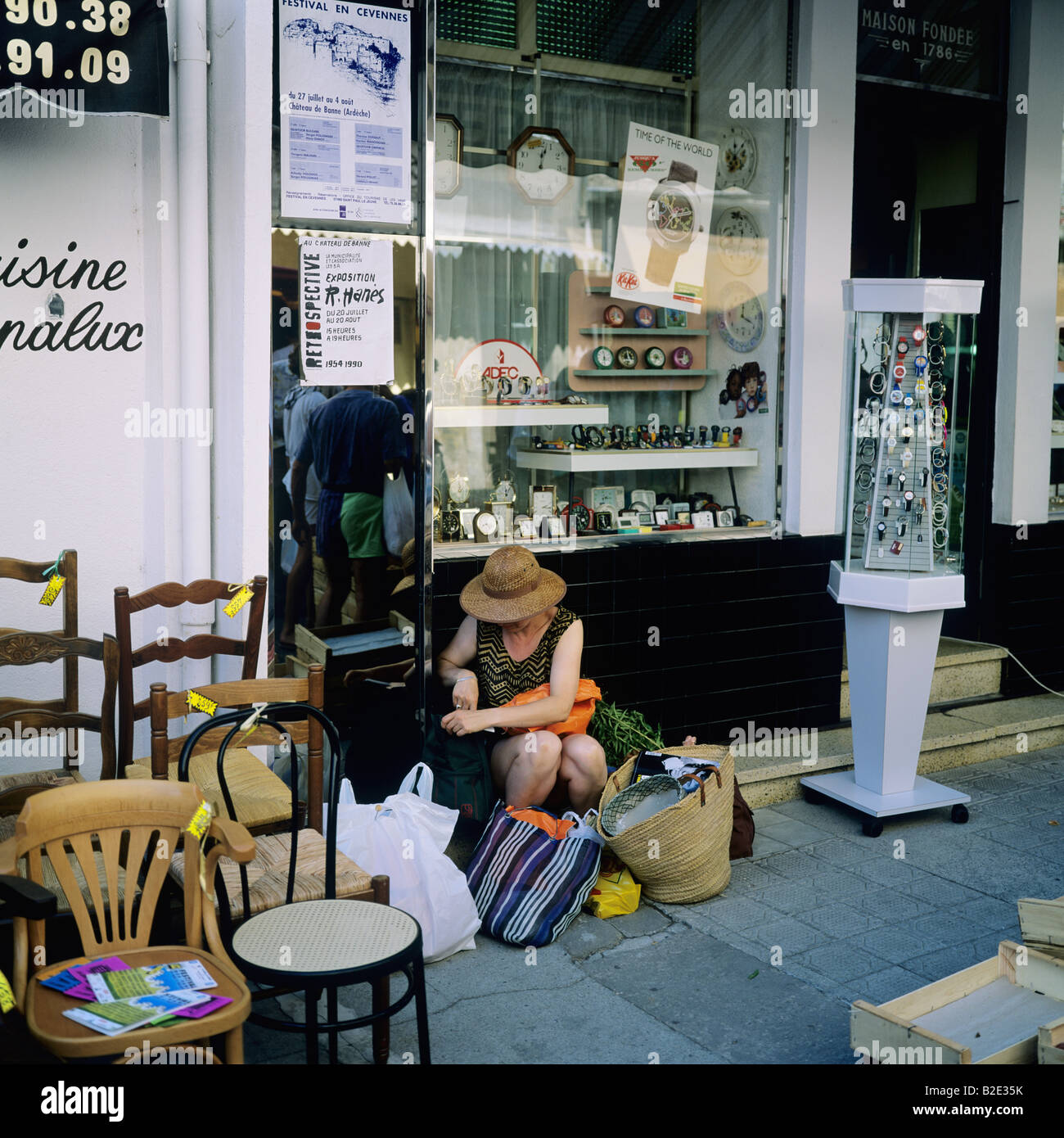 Erschöpfte Frau mit Einkaufstaschen auf dem Straßenbelag, Les Vans, Ardèche, Frankreich, Europa Stockfoto