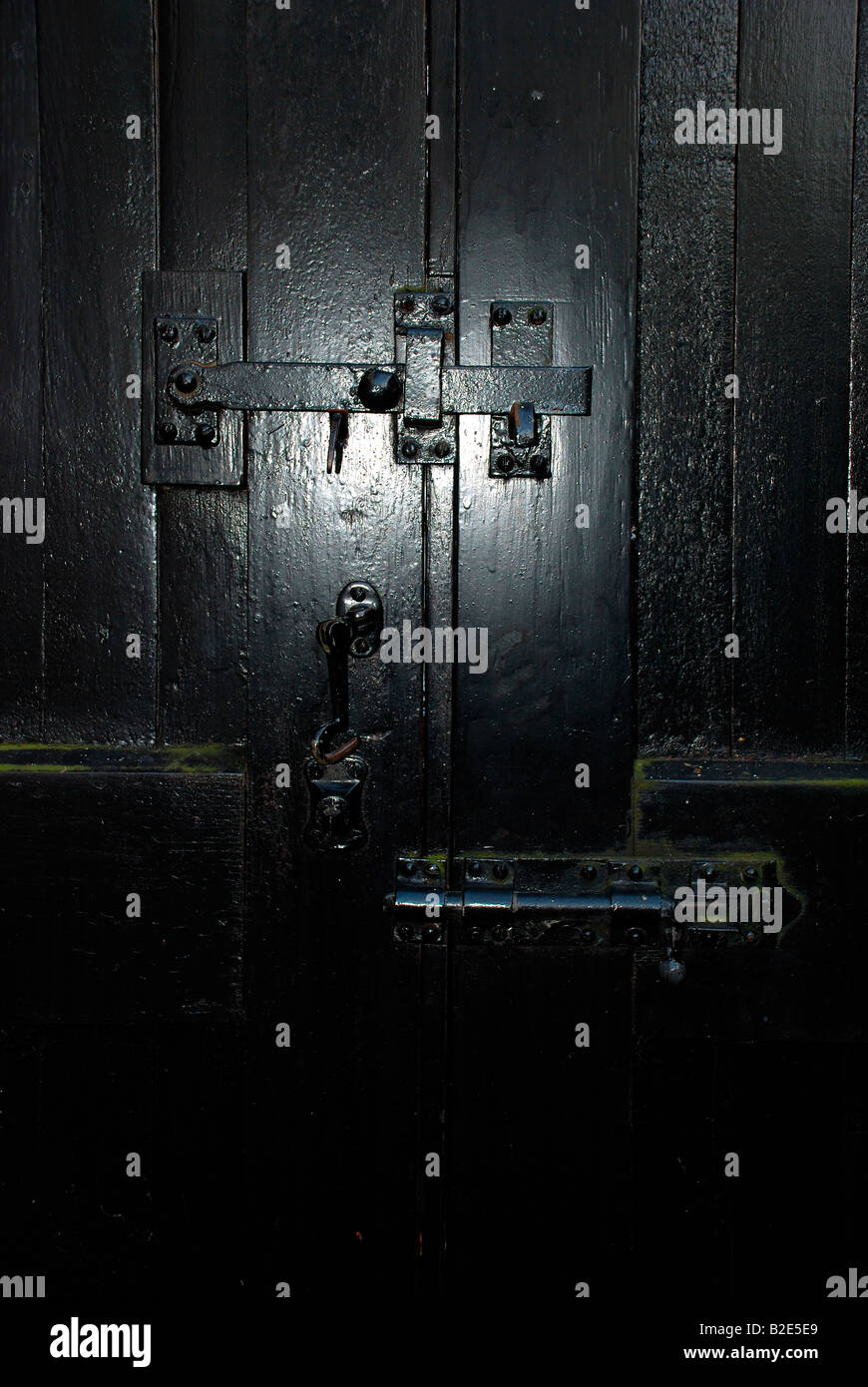 schwarzes Tor Riegel auf schwarz lackiertem Holz mit Bolzen und Tor-Haken-Verriegelung Stockfoto