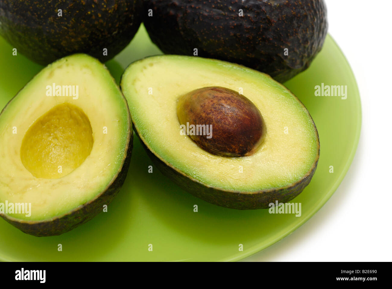 Zwei Avocados eine in Scheiben geschnitten in der Hälfte, Samen ausgesetzt Stockfoto