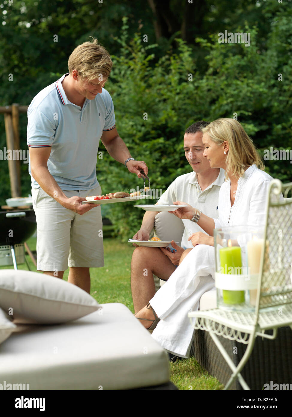 Mann, die Speisen zu seinen Freunden auf einer Gartenparty Stockfoto