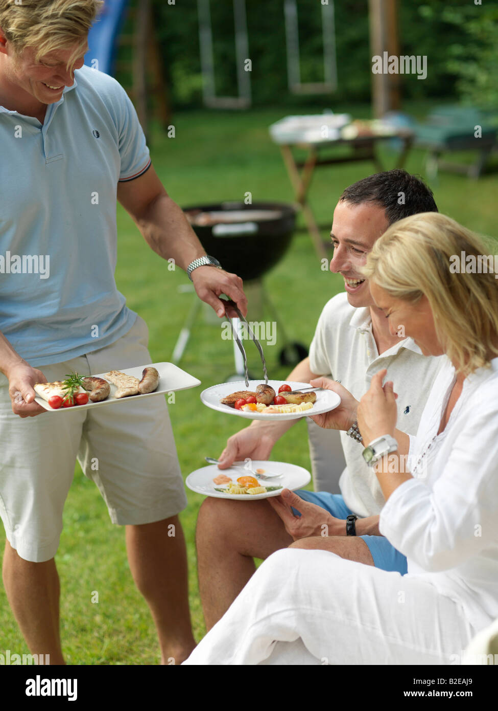 Mann, die Speisen zu seinen Freunden auf einer Gartenparty Stockfoto