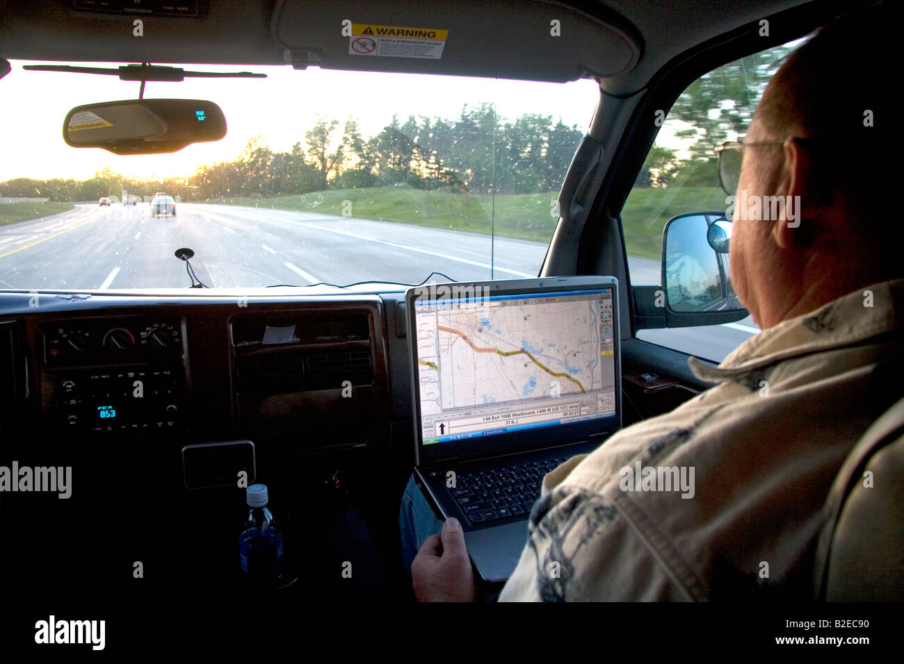 Passagier in einem fahrenden Fahrzeug mit GPS-Navigation auf dem Laptop in Michigan Stockfoto