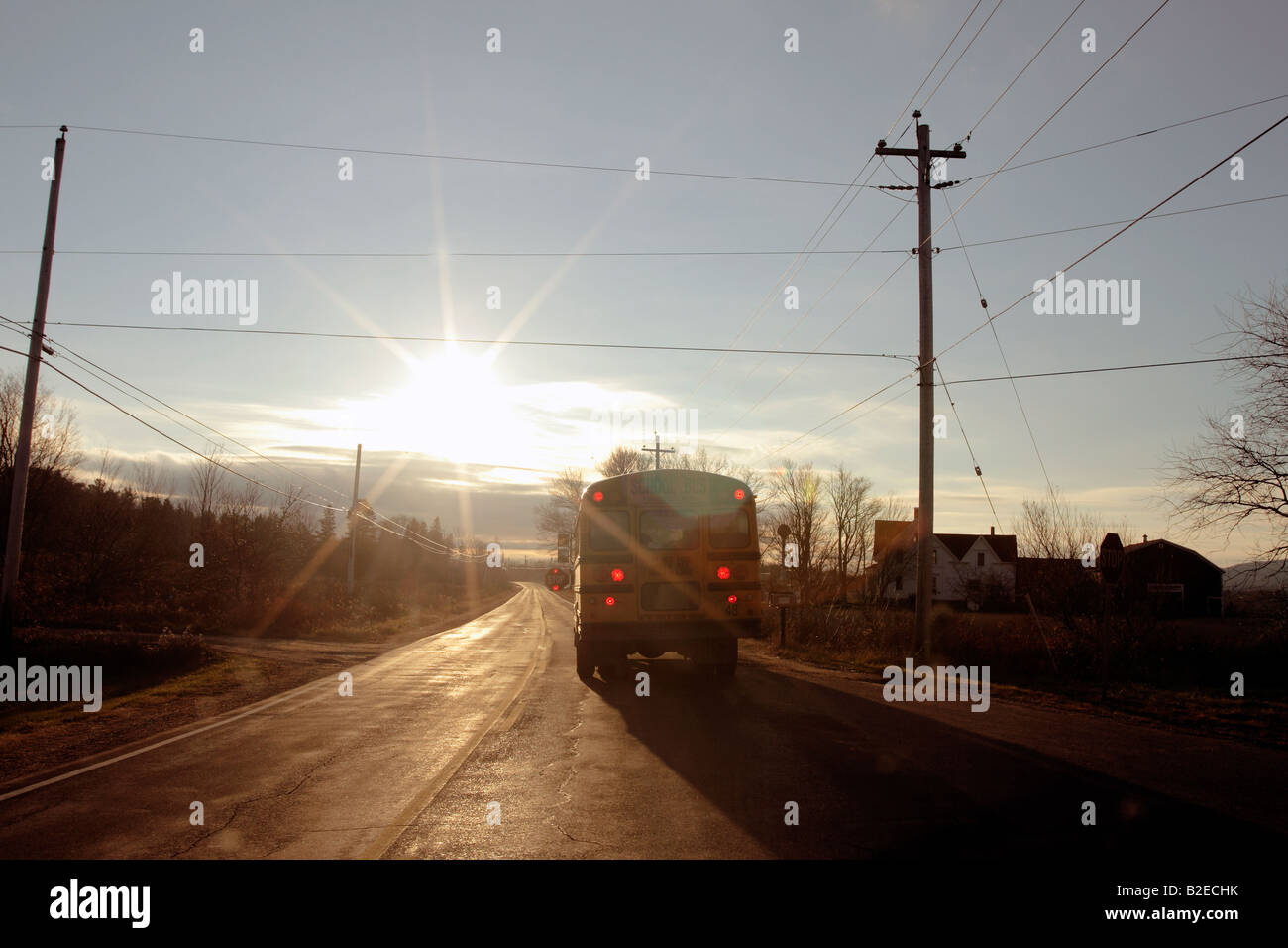 ein Schulbus auf der Autobahn mit einer verhüllenden Sonne Stockfoto