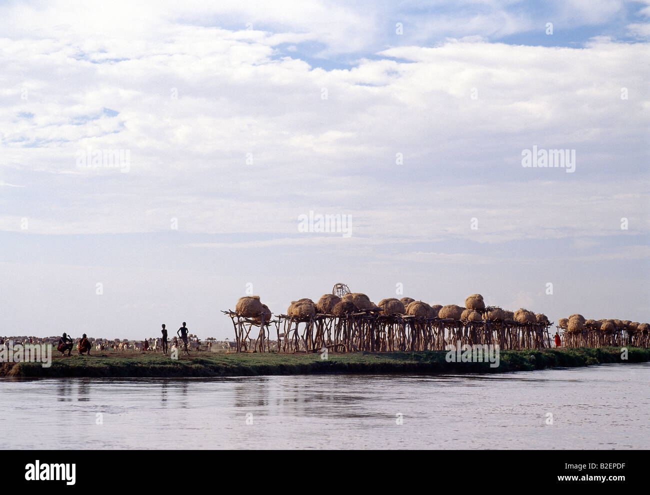 Ein Cluster von Dassanech Getreidespeicher säumen das Ufer des Flusses Omo vor einer großen Siedlung. Stockfoto