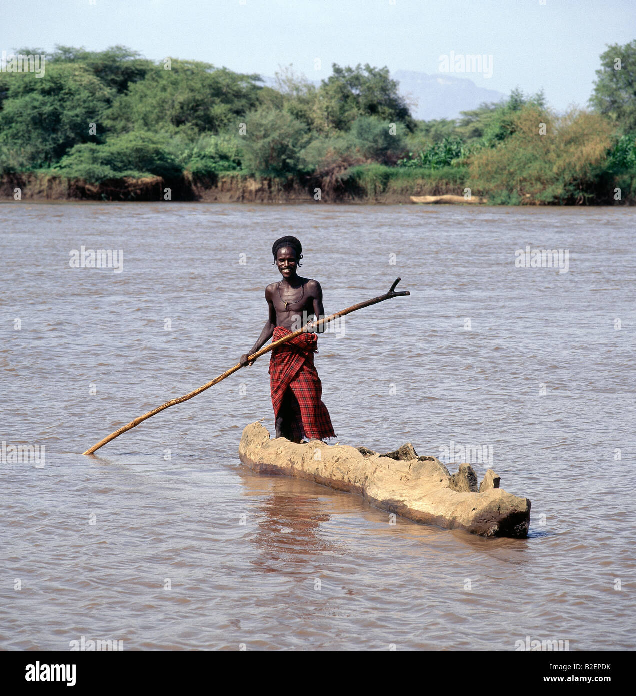 Ein Dassanech Mann Polen eine Einbaum Kanu über den schlammigen Gewässern von einem Nebenfluss des Flusses Omo in seinem Delta in der Nähe von Lake Turkana. Stockfoto