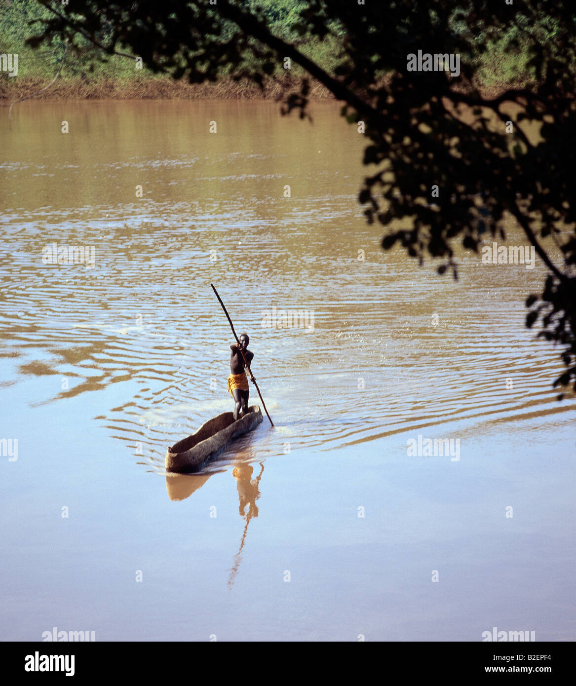 Ein Karo Mann Polen seine Einbaum über den schlammigen Gewässern des Omo River.The Karo sind ein kleiner Stamm. Stockfoto