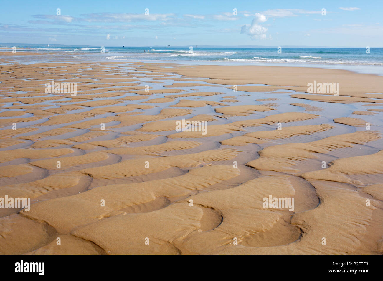 Halbmond-Muster auf einem idyllischen Strand an der Küste von Mosambik. Dhow Segeln in weiter Ferne Stockfoto