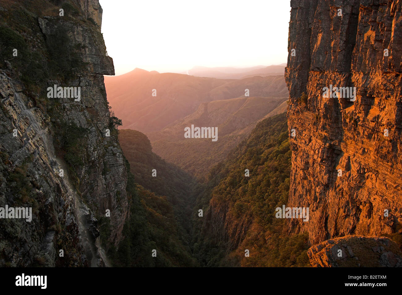 Berglandschaft mit warmer Beleuchtung scheint auf einer steilen Felswand Stockfoto