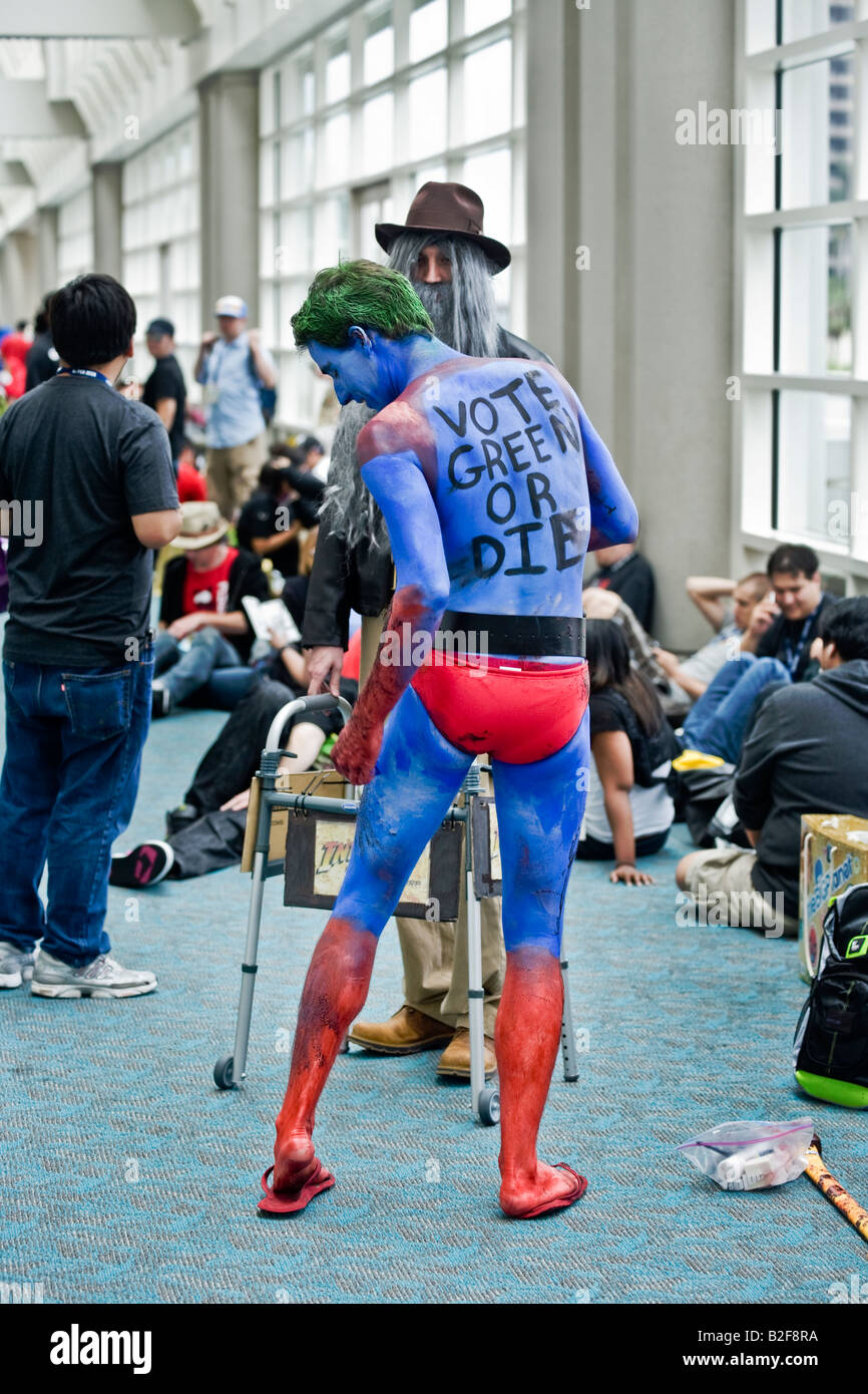 Ein Versammlungsteilnehmer, gekleidet wie eine ökologische Ermahnung seine blau gefärbte Haut bei Comic-Con International in San Diego berührt Stockfoto