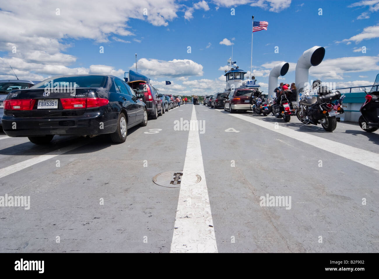 Automobile und Motorräder aufgereiht auf dem Deck der Fähre Stockfoto
