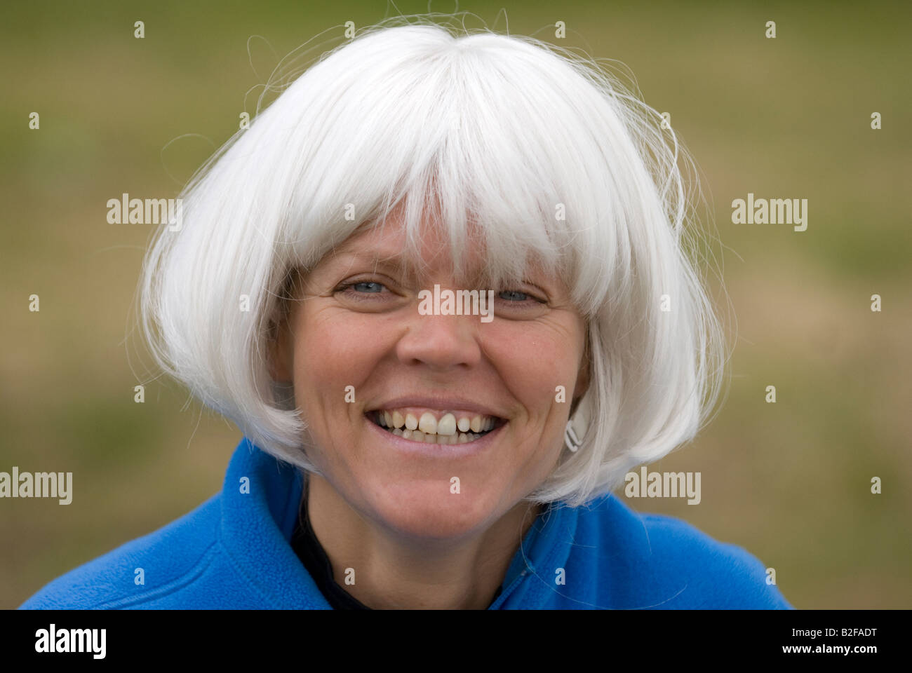 grinsende Frau in weißen Perücke Stockfoto