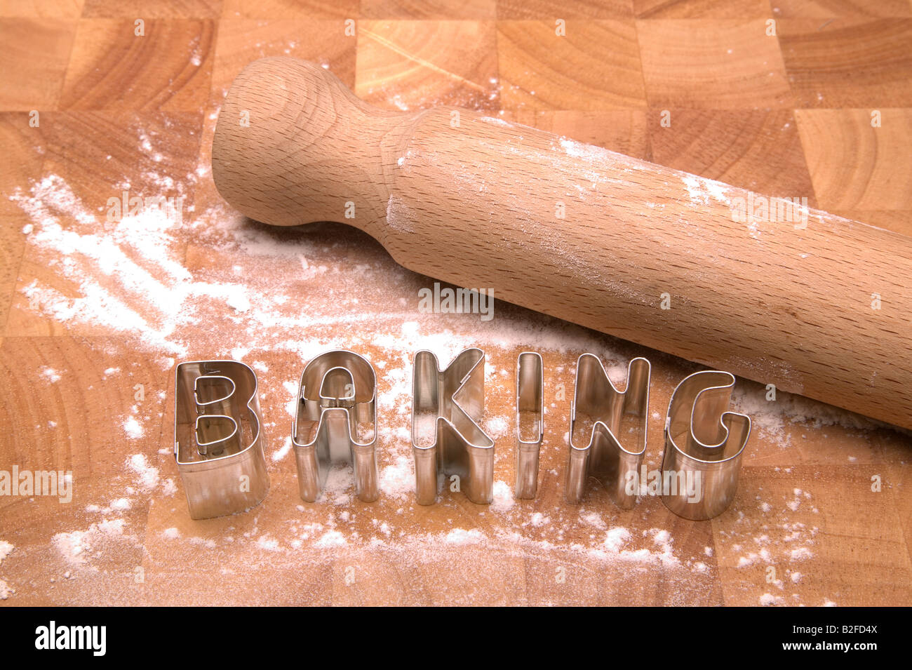 Backen Gesundliche heraus in Kochkunst Buchstaben auf ein Schneidbrett aus Holz mit Mehl und Nudelholz Stockfoto