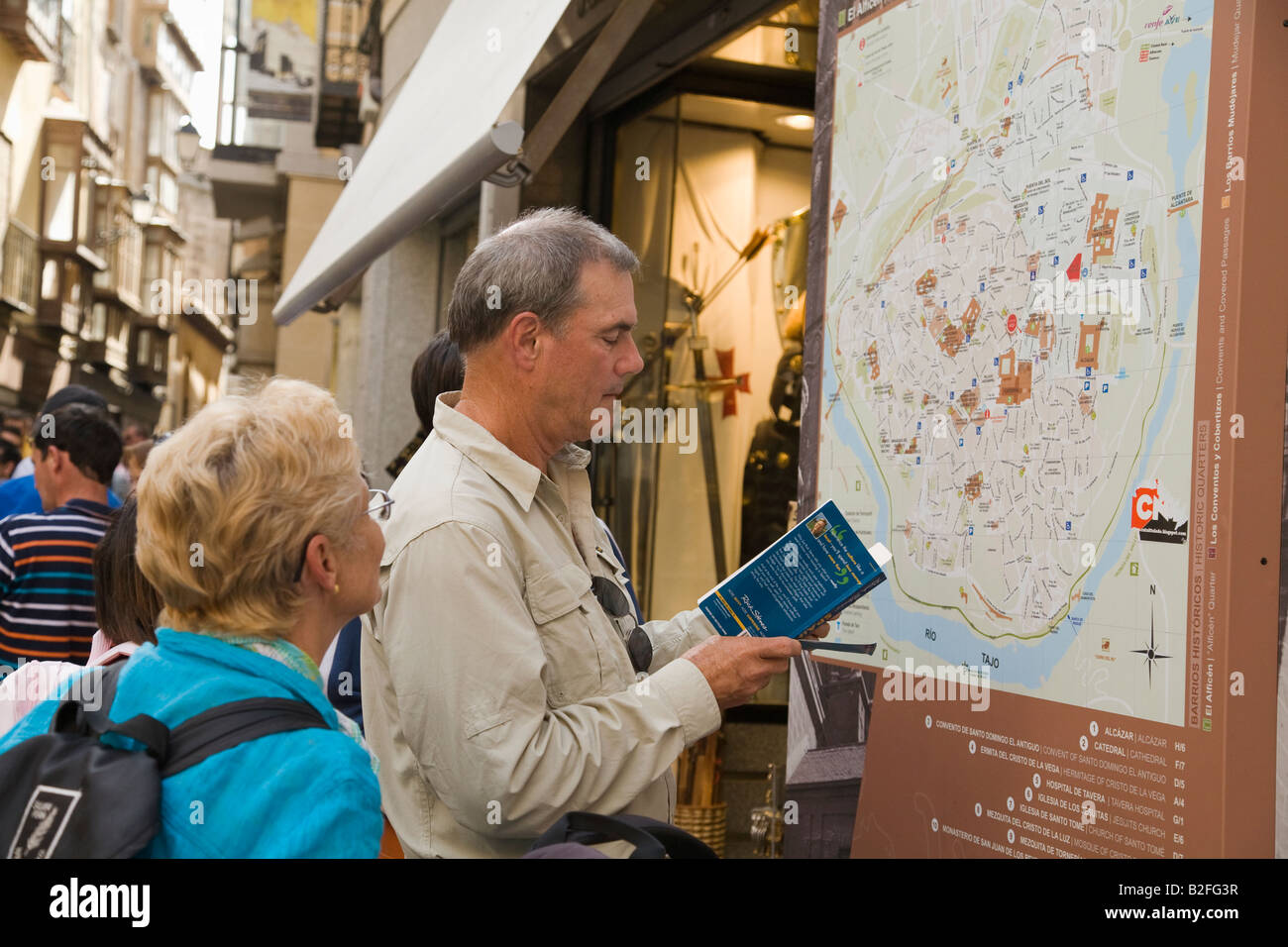 Spanien Reisen Toledo paar zu konsultieren, Toledo Straßenkarte und Rick Steves Reiseführer Buch tragen Rucksäcke und Gepäck Stockfoto