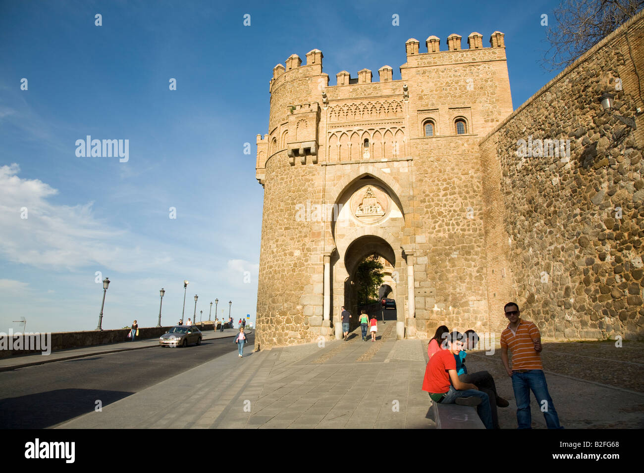 Spanien Toledo Leute sitzen auf der Bank in der Nähe von Tor Puerta del Sol in Stadt-Wand-Mudéjar-Architektur-Stil im 13. Jahrhundert erbaut Stockfoto