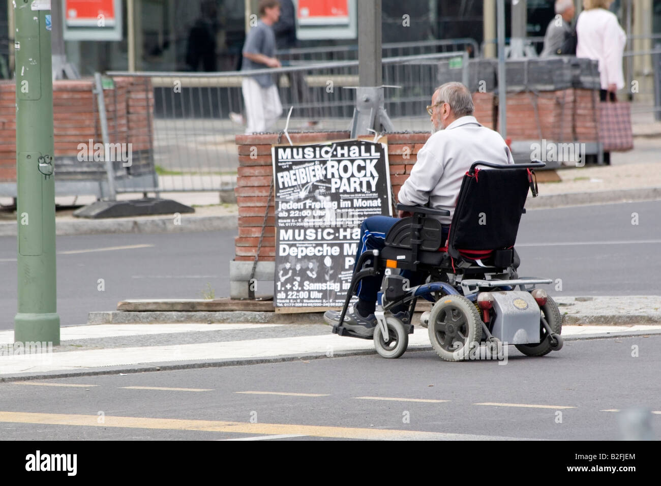 Senior woman in Elektro-Scooter lesen Plakat auf Straße Stockfoto