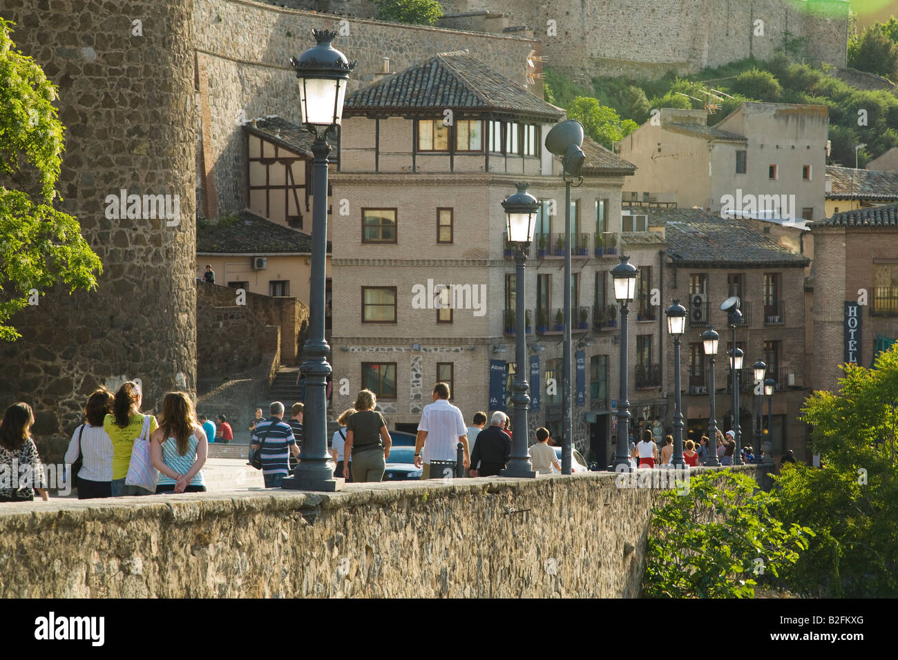 Spanien Toledo Besucher Stadt Fuß bergab in der Nähe von Puerta del Sol-Tor in die Stadt Wandleuchten entlang Gehweg und Stein Gebäude Stockfoto