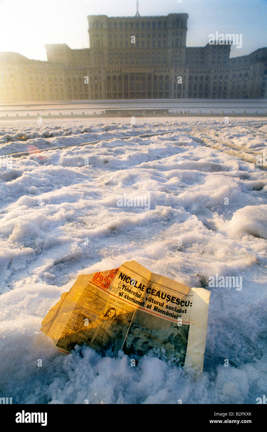 eine alte Zeitung mit Artikel über Ceausescu liegt im Schnee vor dem Haus des Volkes, Bukarest, Rumänien Stockfoto