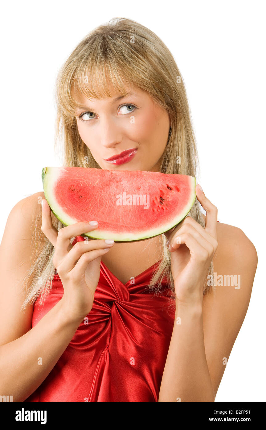 Süße blonde Mädchen im roten Kleid und roten Lippen mit einem Stück Wassermelone Gesicht Stockfoto