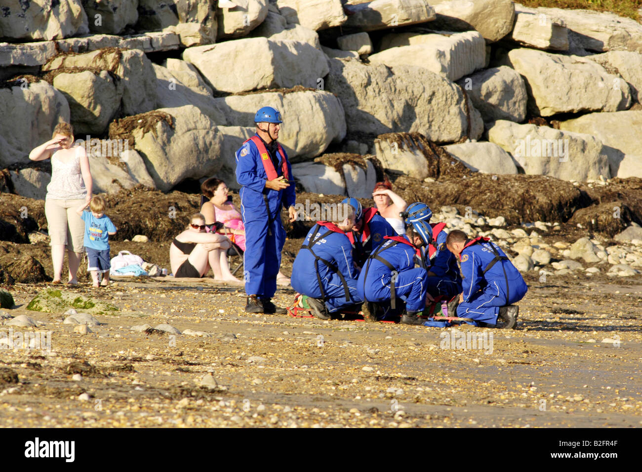 Küstenwache am Ufer Rettung Freiwilligen in blauen Overalls finden eine Stelle am Strand Stockfoto