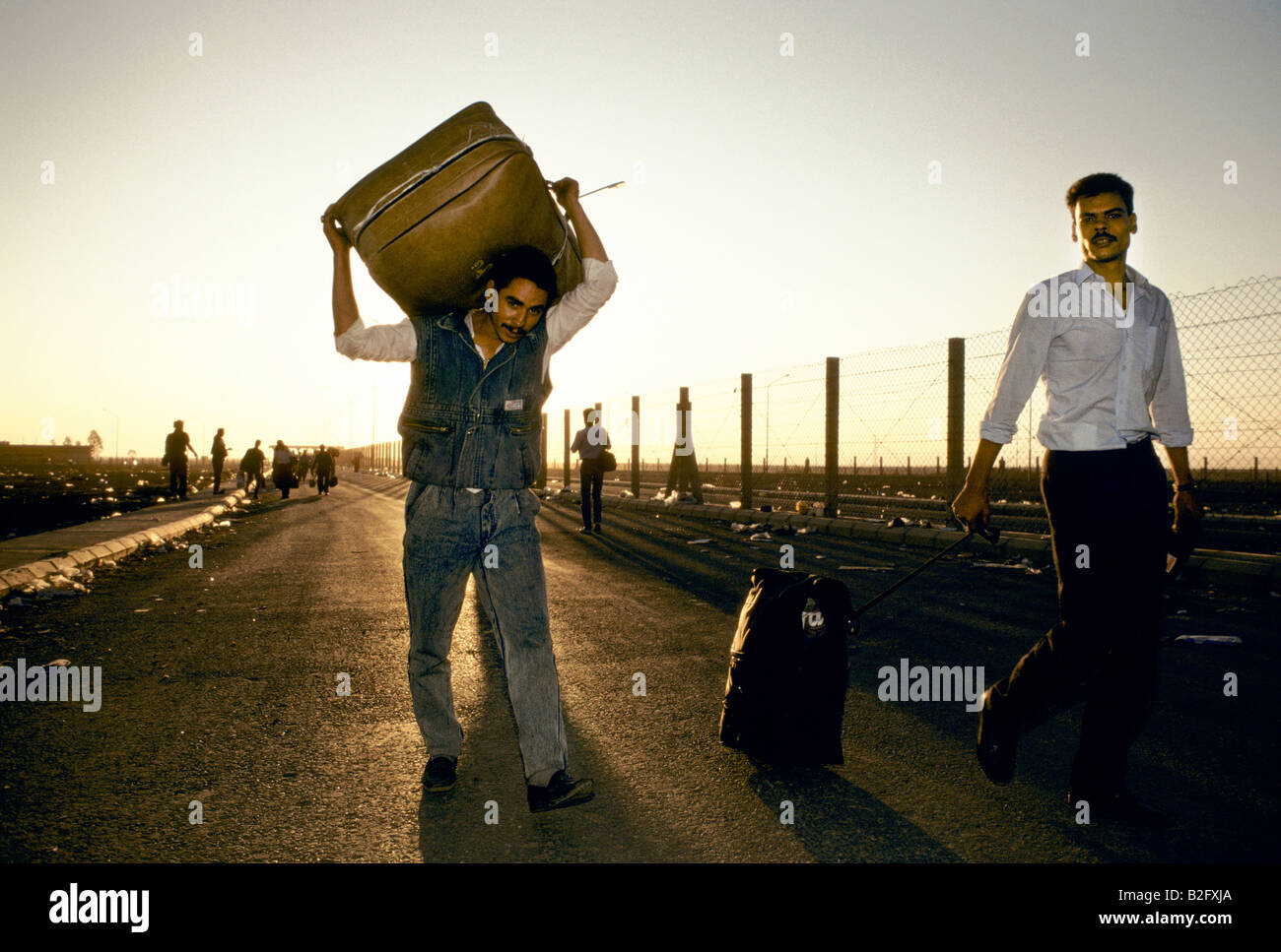 zwei Flüchtling Männer tragen Besitz eine Straße hinunter, während der Golfkrise Stockfoto