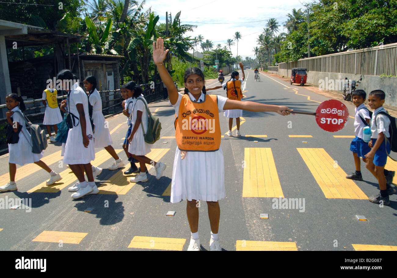 Speziell ausgebildete Schüler als Kreuzung Wächter zu ermöglichen, andere Kinder zu überqueren Straße zu ihrer Schule sicher, Sri Lanka Stockfoto