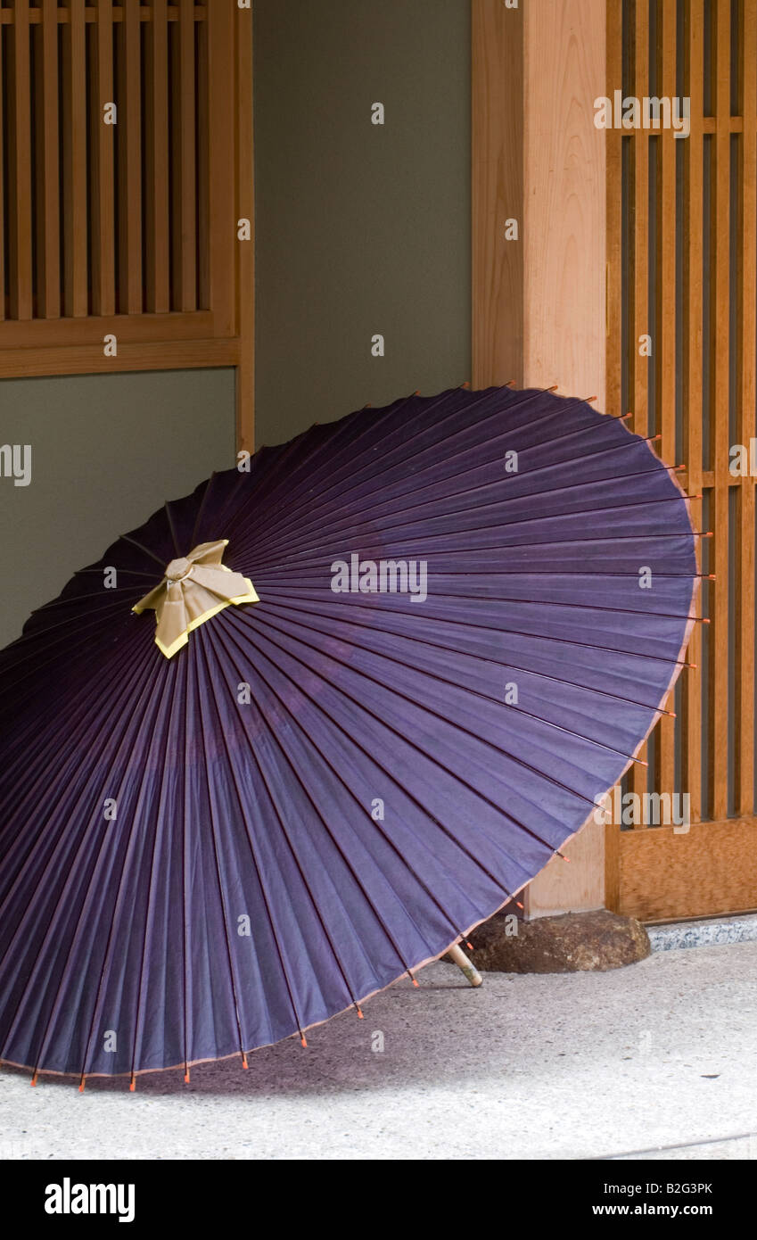 Traditionelle Papier und Bambus Sonnenschirm sitzt neben dem Eingang zu einem Teehaus im Miyagawa-Geisha-Bezirk von Kyoto Stockfoto