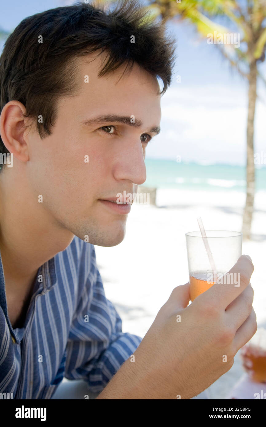 junger Mann Modell trinken cocktail Hotel beach Holliday Junger Mann entschied Einen Cocktail bin Hotelstrand Stockfoto