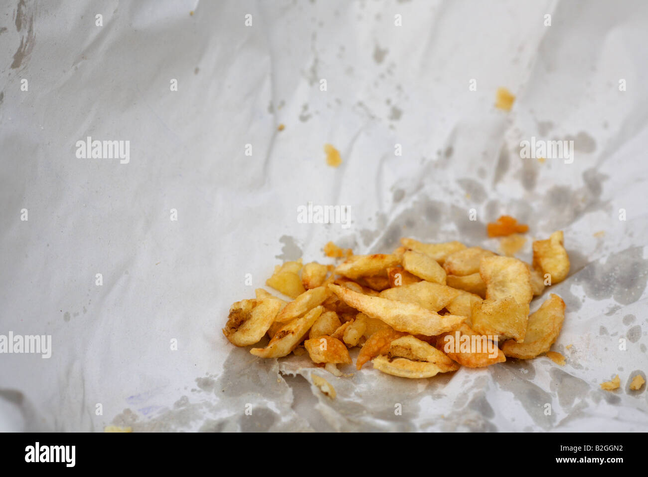 Scrag Ende bleibt ein Teil der Chips in fettigen Weißbuch Wrapper Imbiss Stockfoto