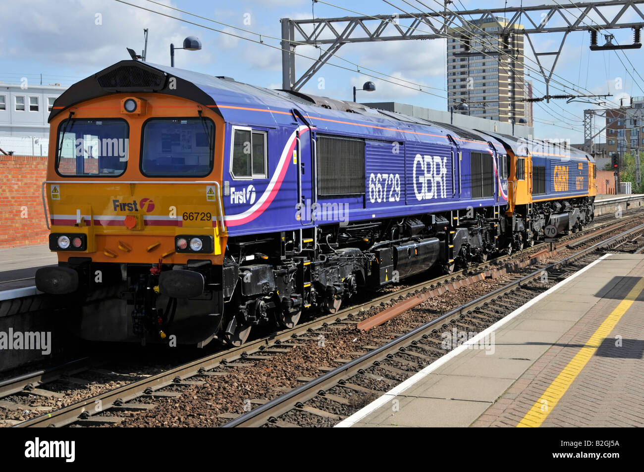 Diesellokomotive 66729 in der ersten GBRf-Lackierung mit Fahrlicht hinter 66717 am Bahnsteig Stratford in East London UK Stockfoto