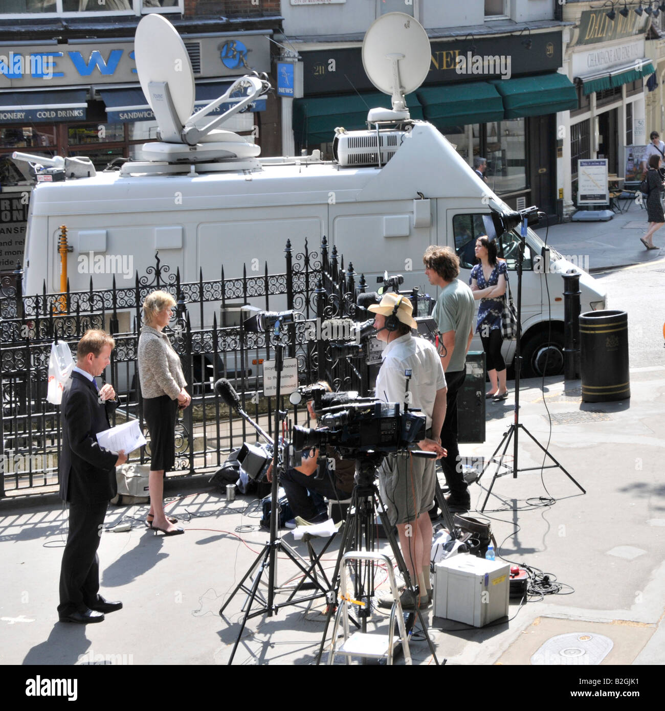 Gegenüber von Royal Courts of Justice Law Courts Journalisten und Reporter mit TV-Kamerateams, die neben der Satellitenschüssel Van London UK Nachrichten schreiben Stockfoto