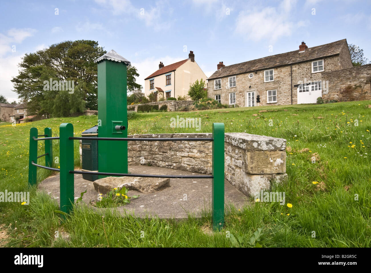 Die alte Wasserpumpe auf dem Dorfplatz am Thornton Steward in North Yorkshire Stockfoto