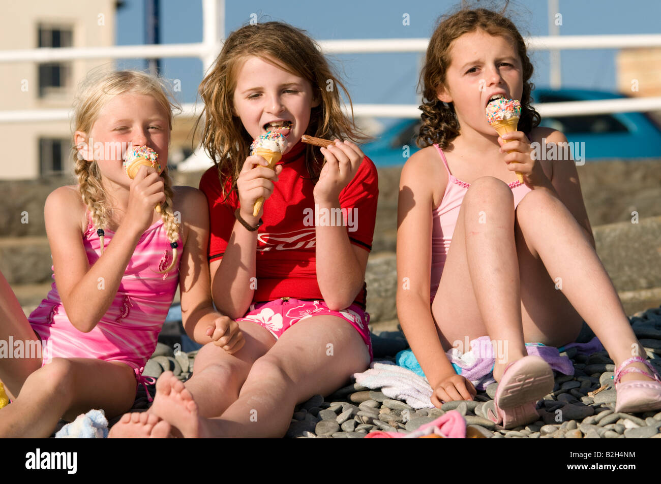 Drei Junge Mädchen Neun Jahre Alt Im Urlaub Essen Eis Sitzen Am Strand Sommernachmittag 7829