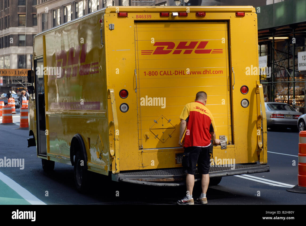 Ein DHL-Mitarbeiter und seinen LKW sind im Garment District in New York gesehen. Stockfoto