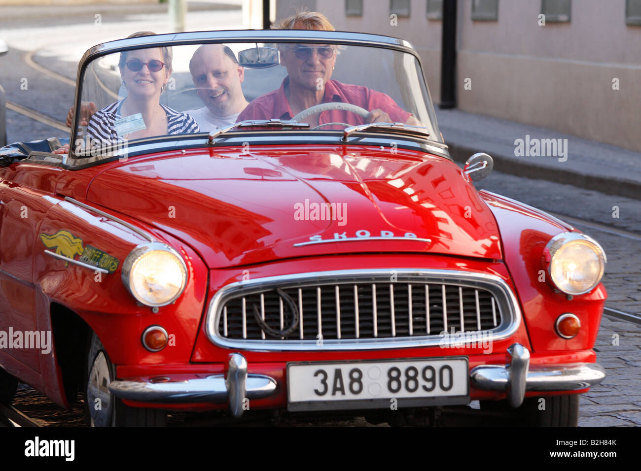Alte Klassiker der roten Cabrio tschechischen Skoda mit Touristen und Fahrer auf eine Sightseeing-Tour durch die alten Viertel von Prag Stockfoto