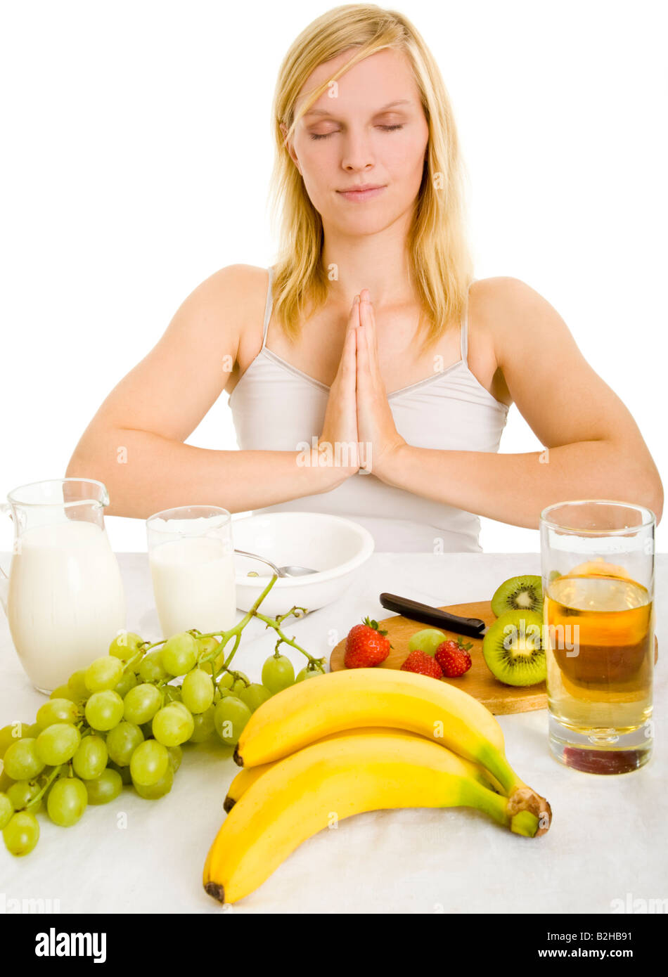 Junge, blonde Frau Frühstück Tabelle Obst gesunde Lebensmittel Morgen Bananen Äpfel Trauben Körper Pflege Wellness Entspannung Stockfoto