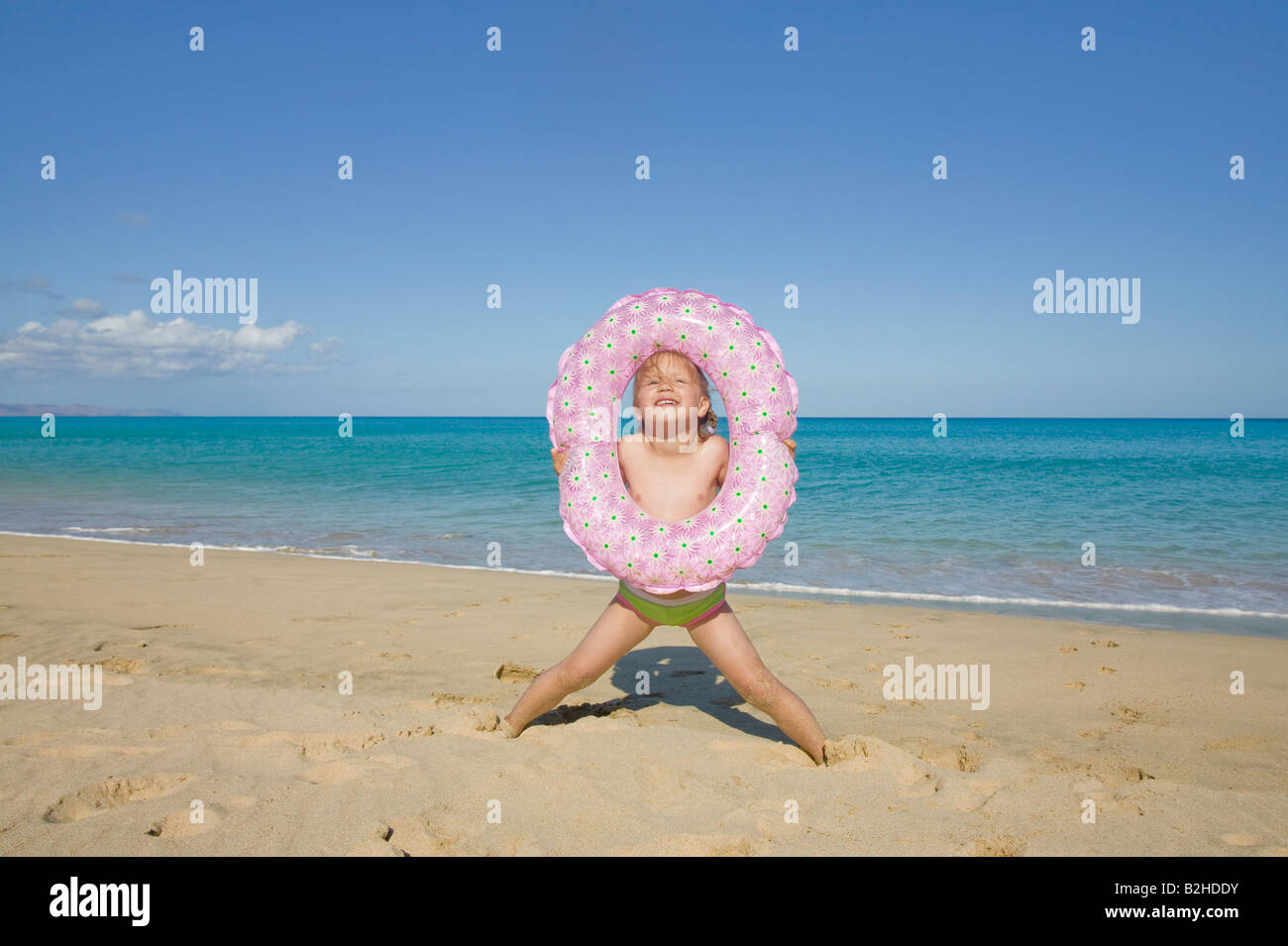kleines Mädchen mit schwimmenden Reifen am Strand Stockfoto