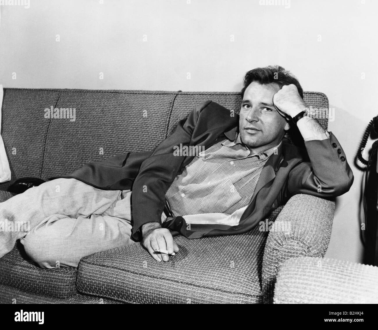 Burton, Richard, 10.11.1925 - 5.8.1984, britischer Schauspieler, halbe Länge, auf dem Sofa liegend, 1950er Jahre, Stockfoto