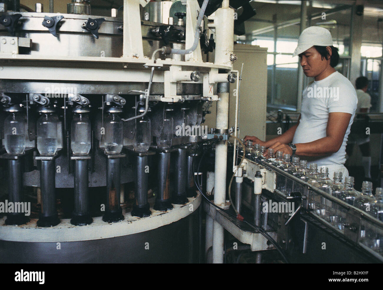Australien. Mann, der an der Produktionslinie arbeitet. Klare Glasflaschen. Stockfoto