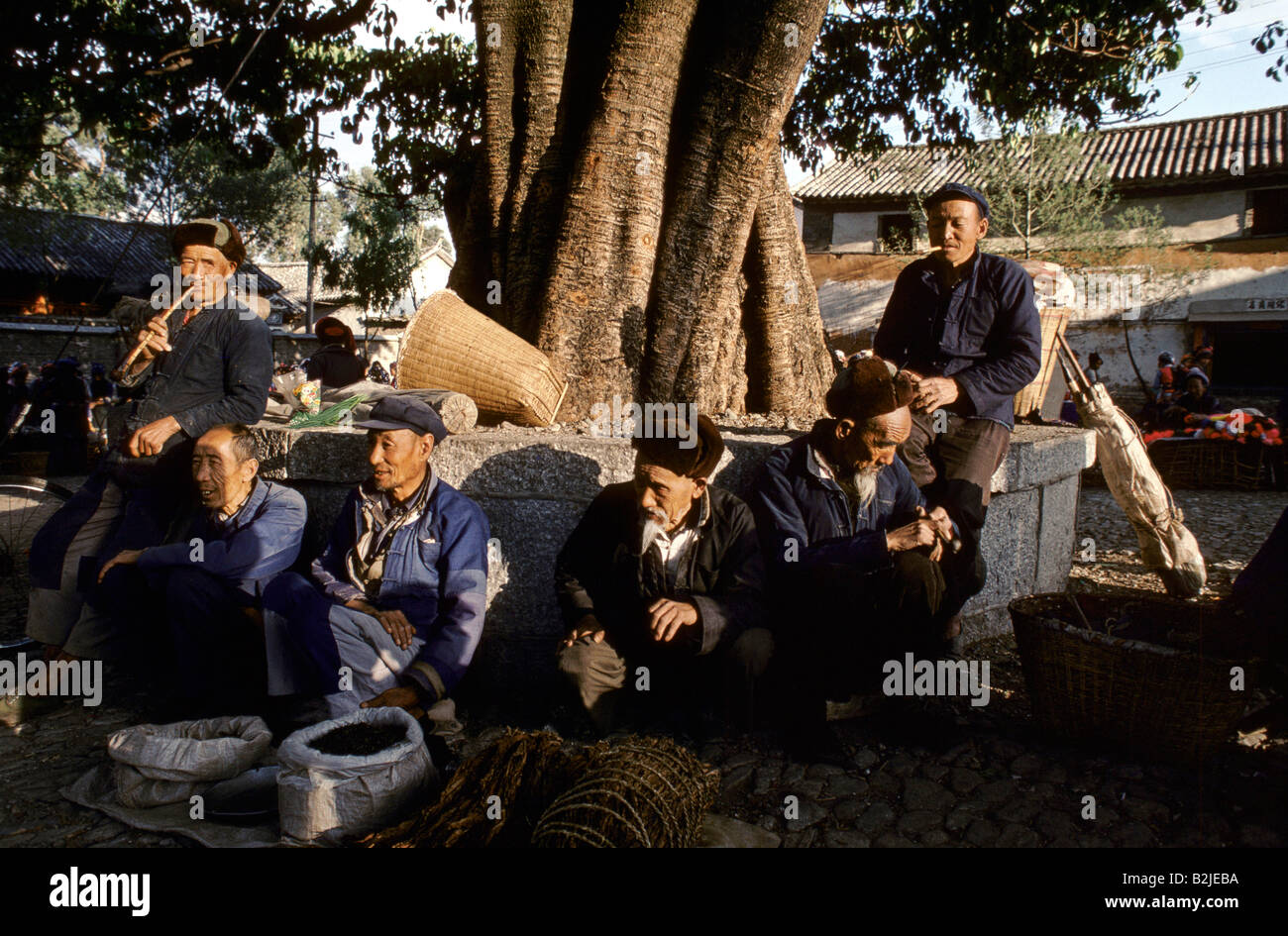 Männer sitzen neben einem Baum verkaufen Dali Yunnan Provinz China Stockfoto