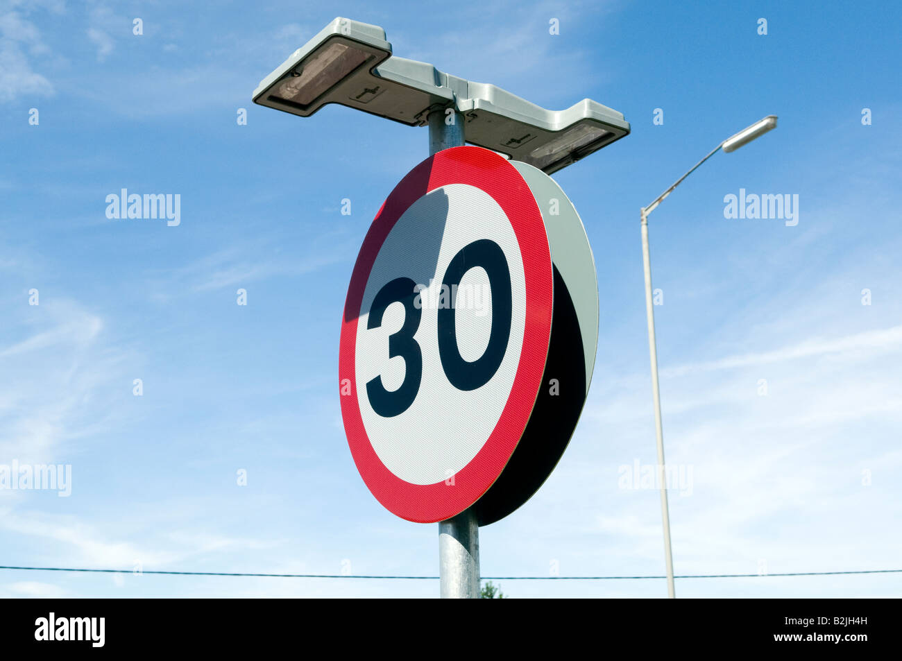 30 30 km/h Meilen pro Stunde, das Straßenschild mit Lichtern an der Seite der Straße an einem sonnigen Tag hautnah Stockfoto